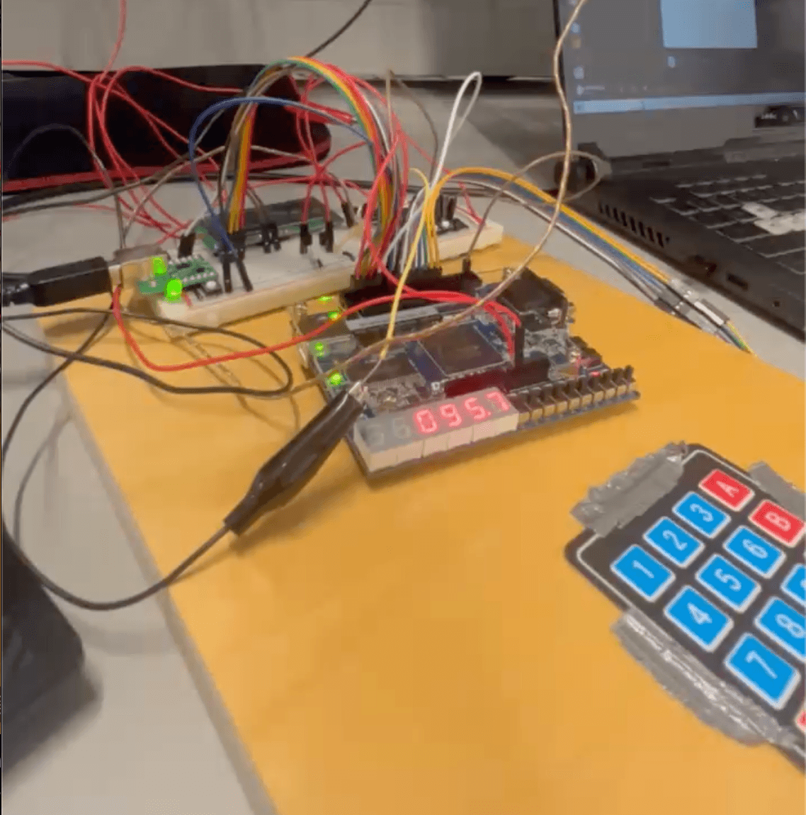 Controller breadboard mid-run: 7-segment showing the current oven temperature, status LEDs lit, keypad in frame