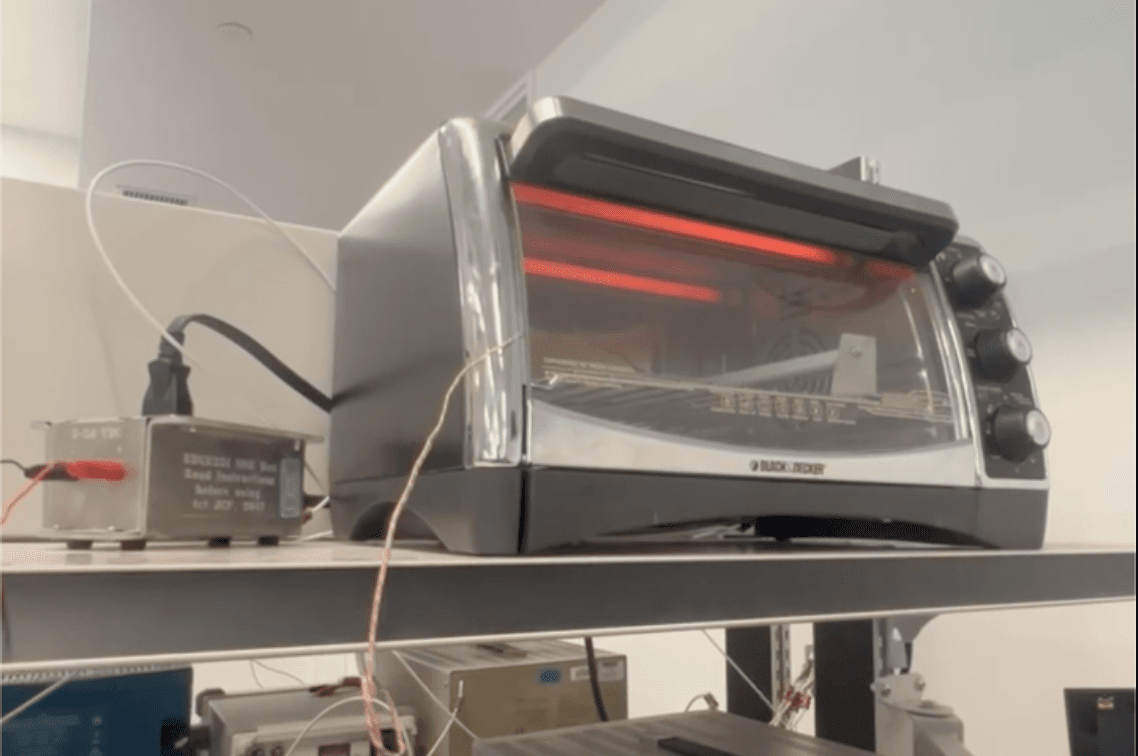 Toaster oven mid-cycle with the heating elements glowing through the door